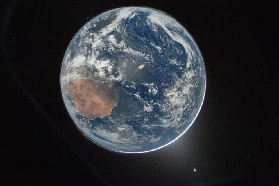 Dalam foto tahun 2026 ini, Bumi tampak di tengah latar belakang hitam angkasa yang tak berujung, awan putih berputar-putar mengelilingi planet biru, Afrika terlihat jelas, dan aurora borealis bersinar di sudut gambar 