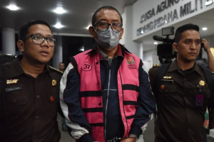 Direktur Pemberitaan JakTV Tian Bahtiar (tengah) dikawal petugas menuju mobil tahanan usai menjalani pemeriksaan di Gedung Kejaksaan Agung, Jakarta, Selasa (22/4/2025).