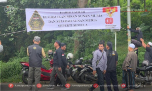 Anggota PWI-LS memasang spanduk di jalan menuju Makam Sunan Muria 